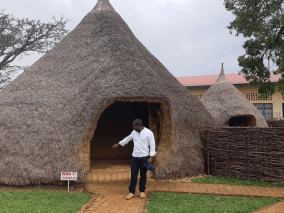 manmade hut with owner in front